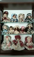 Verzameling porseleinen popjes in vitrinekastje van