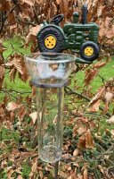 Metalen regenmeter met gietijzeren tractor en